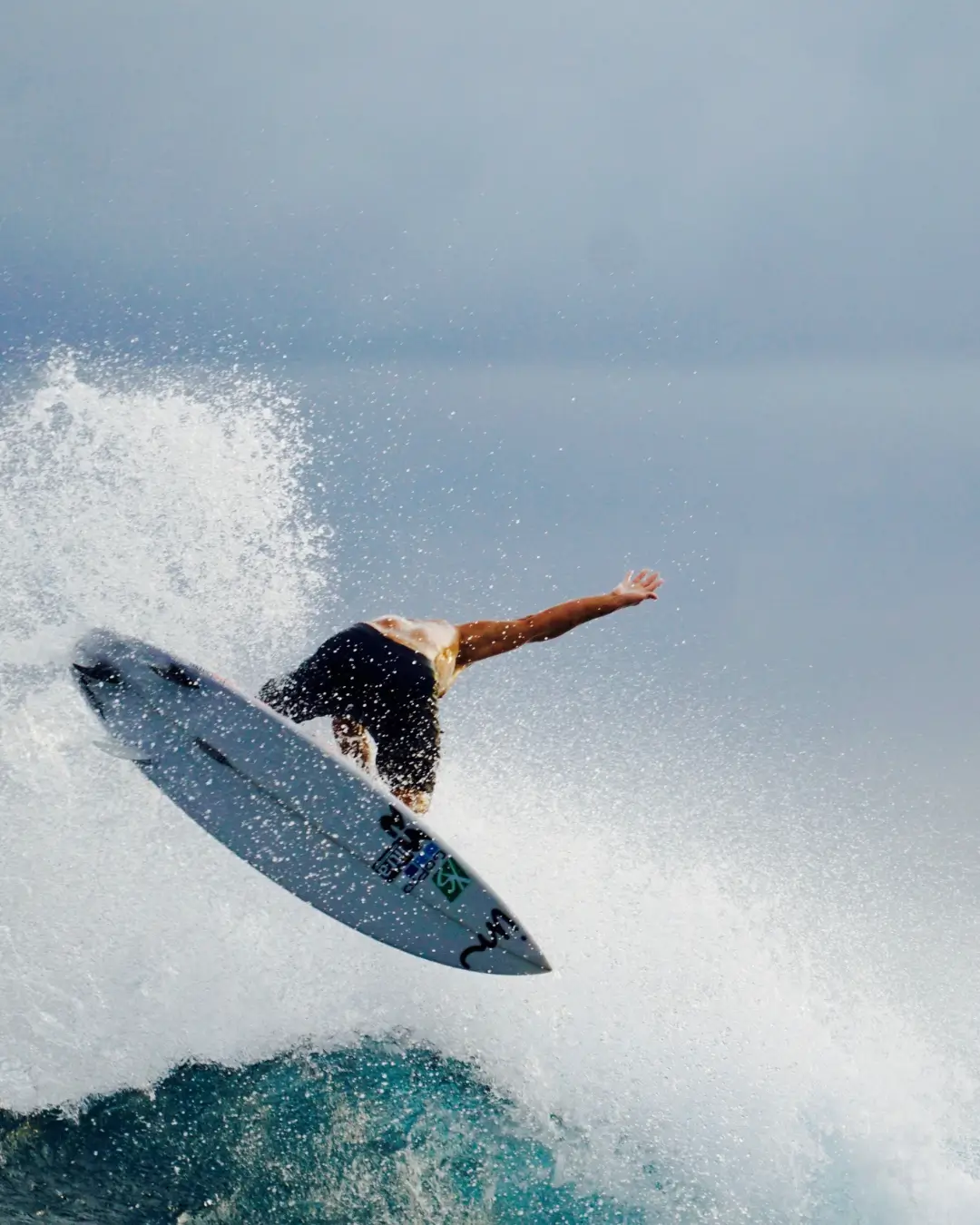 mentawai surf resort safety - a man is surfing, only his board is seen and his back. He is turned away from the camera